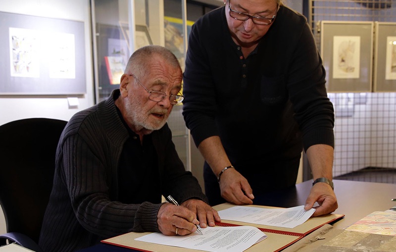 Vertragsunterschrift mit dem Karikaturisten Reiner Schwalme